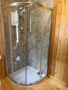 a shower with a glass enclosure in a room at Spacious eco-energy timber barn in Chadbury in Offenham