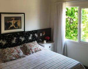 1 dormitorio con cama y ventana en Suites Campestres CDG, en Rio Negrinho