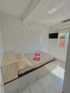 Bett in einem Zimmer mit einem TV an der Wand in der Unterkunft Pousada Realce in Vera Cruz de Itaparica
