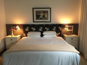 ein Schlafzimmer mit einem großen Bett mit zwei Nachttischen in der Unterkunft Suites Campestres CDG in Rio Negrinho + 7 Fotos