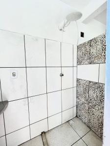 a bathroom with a shower with white tiles at Pousada Realce in Vera Cruz de Itaparica