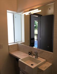 a bathroom with a sink and a large mirror at Suites Campestres CDG in Rio Negrinho