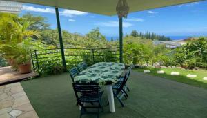 a table and chairs on a patio with a view of the ocean at Tahiti RevaMiti EcoLodge in Punaauia