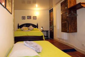 1 dormitorio con 2 camas con sábanas amarillas en Casa Encuentro Ecolodge, en Guatapé