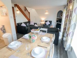een woonkamer met een tafel en een bank bij Cha Cha's Cottage in Whitby