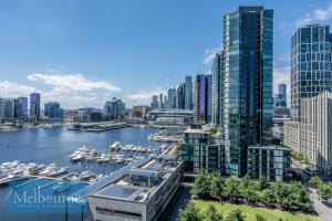 a view of a city with boats in a harbor at Melbourne Private Apartments - Collins Wharf Waterfront, Docklands in Melbourne