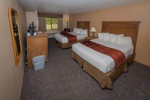 una camera d'albergo con due letti e una televisione di Cowlitz River Lodge a Packwood