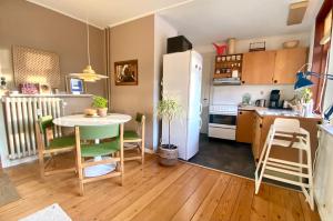 a kitchen with a table and a white refrigerator at Charmerende centralbeliggende lejlighed - hyggelig og med parkering in Randers