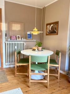 een tafel en stoelen in een kamer met een tafel en een eetkamer bij En hel lejlighed i midtbyen - centralt, hyggelig og tæt på alt! in Randers