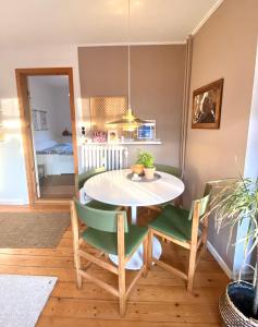 ein Esszimmer mit einem weißen Tisch und grünen Stühlen in der Unterkunft En hel lejlighed i midtbyen - centralt, hyggelig og tæt på alt! in Randers