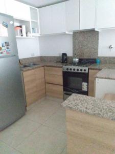 馬德琳港的住宿－Hermoso depto en excelente ubicacion，厨房配有冰箱和炉灶。 顶部烤箱
