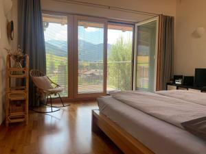 a bedroom with a bed and a chair and a window at Chalet Steinernes Meer in Maria Alm am Steinernen Meer