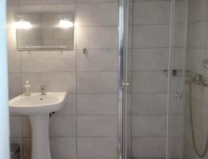 een witte badkamer met een wastafel en een douche bij Palm Suite Yellow in Porto Cheli