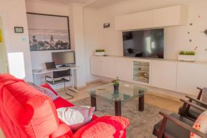 sala de estar con sofá rojo y mesa de cristal en Appartement Limonar del Golf - Full Option, en Mijas Costa