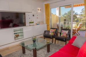 Una sala de estar con un sofá rojo y sillas. en Appartement Limonar del Golf - Full Option, en Mijas Costa