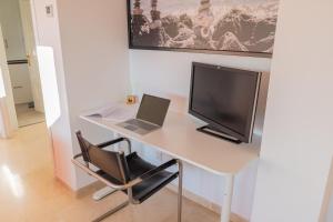 een bureau met een laptop en een computermonitor bij Appartement Limonar del Golf - Full Option in Mijas Costa