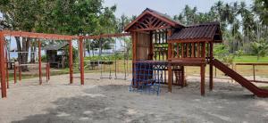 un parque infantil de madera con un tobogán en un parque en Eastwind Beach Club- El Nido, en El Nido