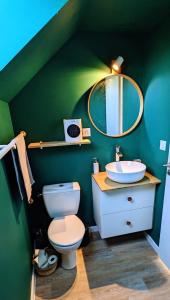 uma casa de banho verde com um WC e um lavatório em Charmant gîte à la ferme em Herbignac