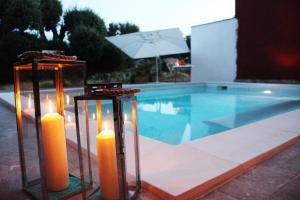 two candles in front of a swimming pool at Bio Casale Marchesi in Casarano