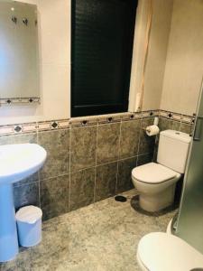 ein Badezimmer mit einem WC, einem Waschbecken und einem Spiegel in der Unterkunft Piso moderno in Sarria