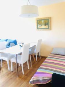 ein Esszimmer mit einem Tisch, Stühlen und einem Teppich in der Unterkunft Piso moderno in Sarria