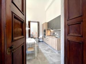 cocina y comedor con mesa y puerta en Happy Family Apartments U Papaviou, en Génova