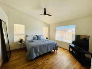 a bedroom with a bed and a ceiling fan at Glendale Gem with Pool & Office in Prime Location in Glendale