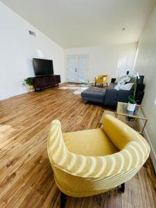 a living room with a yellow chair and a couch at Glendale Gem with Pool & Office in Prime Location in Glendale