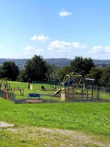 a park with a playground with slides and swings at Private apartment in Wrose, Shipley, Bradford in Shipley