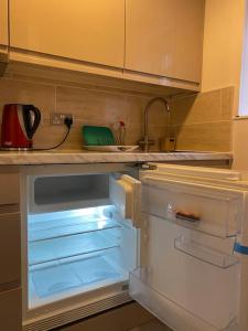 una nevera vacía con la puerta abierta en una cocina en Private apartment in Wrose, Shipley, Bradford, en Shipley
