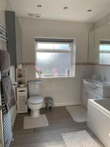 łazienka z toaletą, umywalką i oknem w obiekcie Private apartment in Wrose, Shipley, Bradford w mieście Shipley