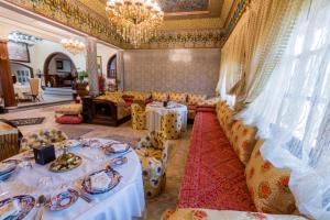 une salle à manger avec des tables et des chaises ainsi qu'un lustre dans l'établissement Riad Sebti Fès, à Fès