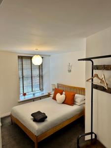 a bedroom with a bed with orange and white pillows at Brechin Townhouse - Cathedral View in Brechin