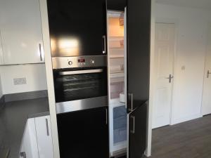a kitchen with an oven and a refrigerator at St Martins House Birmingham Near the NEC, Jaguar Land Rover, HS2, Resorts World, Bear Grylls Centre and Birmingham Airport, with garage and free allocated parking, perfect for contractors and families in Kingshurst