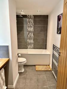 a bathroom with a bath tub and a toilet at Brechin Townhouse - Cathedral View in Brechin