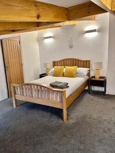 a bedroom with a wooden bed with yellow pillows at Brechin Townhouse - Cathedral View in Brechin