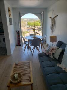 uma sala de estar com um sofá azul e uma mesa em Bienvenue chez nous em Gruissan