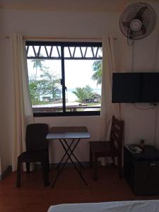 a room with a table and two chairs and a window at MLB Beachfront Apartment in Siquijor
