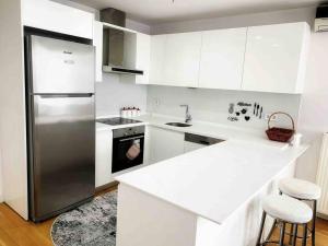 eine Küche mit weißen Schränken und einem Kühlschrank aus Edelstahl in der Unterkunft Full Panoramic Suite Residence in Istanbul