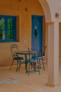 una mesa y sillas frente a una puerta en Auberge Les Roches en Merzouga