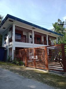 a house with a wooden fence in front of it at MLB Beachfront Apartment in Siquijor