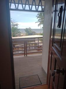 a door to a balcony with a view of the beach at MLB Beachfront Apartment in Siquijor
