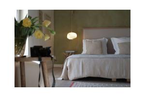 una camera con letto e vaso di fiori di Les Jardins de Sitaara a Cucuron