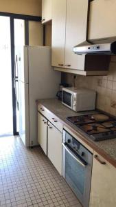 cocina con armarios blancos y fogones en Maison Bourg des Anses d'Arlet en Les Anses-dʼArlets