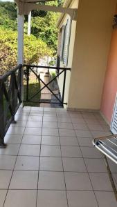 a porch of a house with a gate and a tiled floor at Maison Bourg des Anses d'Arlet in Les Anses-dʼArlets