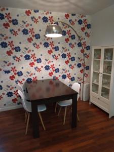 a dining room with a table and flowers on the wall at Piso amplio y tranquilo en Marchena in Marchena +6 photos