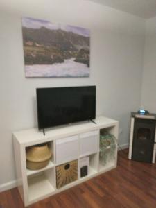 a white entertainment center with a flat screen tv on it at Piso amplio y tranquilo en Marchena in Marchena