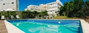 Ein Swimmingpool vor einem Gebäude mit einem Sonnenschirm in der Unterkunft Hotel Milano in Punta del Este