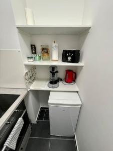 eine kleine Küche mit einer weißen Arbeitsplatte und einer Kaffeemaschine in der Unterkunft City Apartment - E.C.E-Center - Smart TV in Karlsruhe