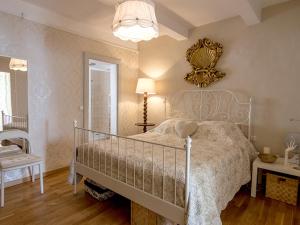 sypialnia z białym łóżkiem i żyrandolem w obiekcie Maison charmante à Bouzigues, proche port et plage - FR-1-604-32 w mieście Bouzigues